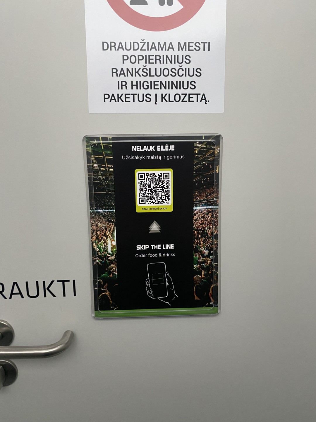 Plakatai arenos tualetuose ant durų