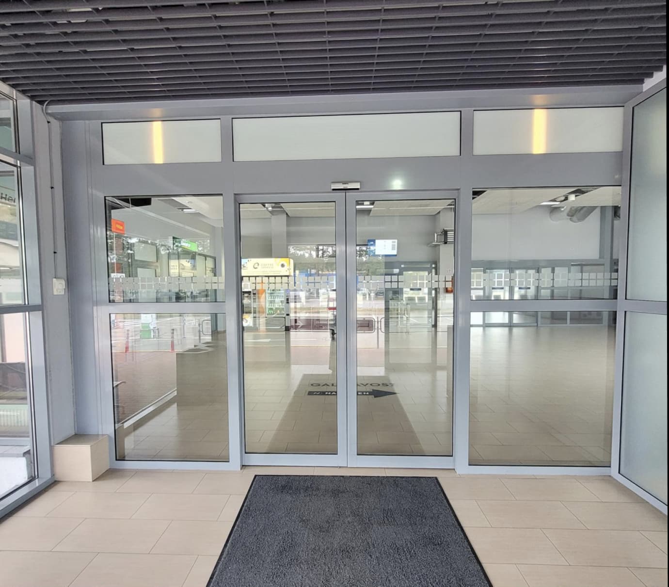 Lipdukas ant durų (Šengeno atvykimo/laukimo salė)